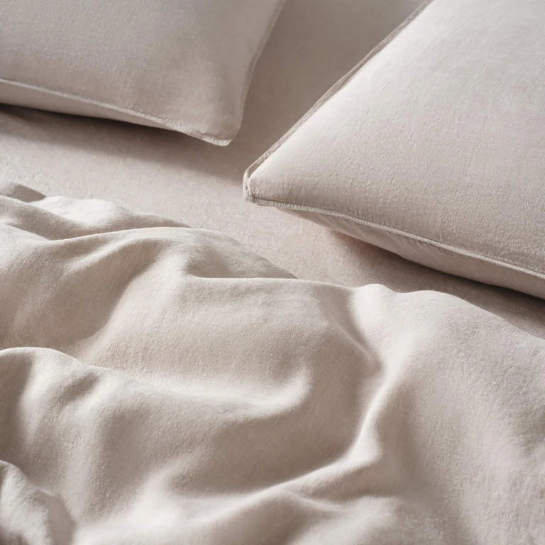 Oatmeal-colored linen sheets styled in bed