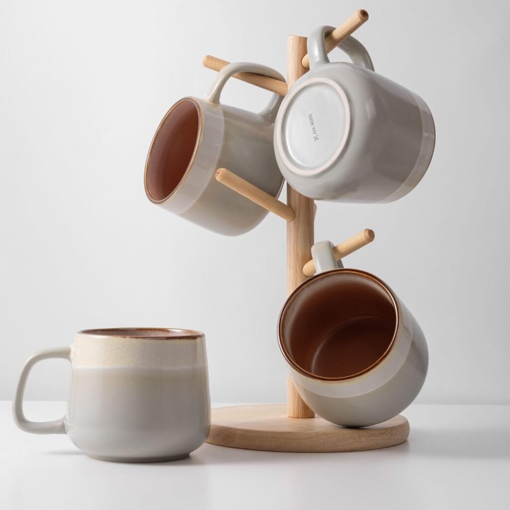 Neutral-toned ceramic mugs hanging on a wooden stand