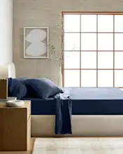 European linen sheet set on a modern bed, styled for casual luxury in a bright bedroom.