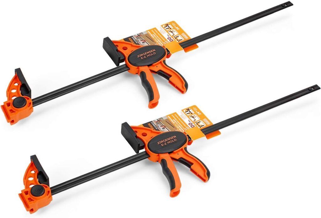 Pair of orange bar clamps holding wooden boards