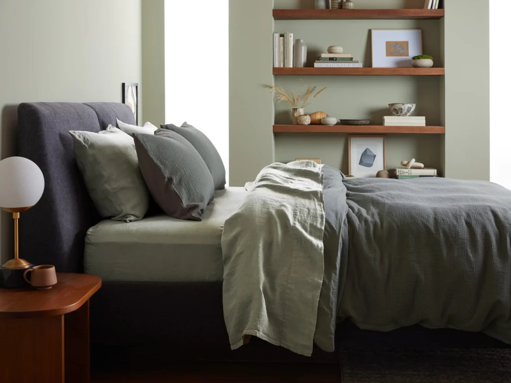 Neutral-toned bed with linen sheets and cushions