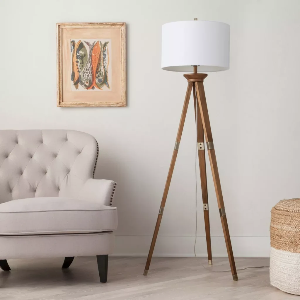 Oakwood tripod floor lamp beside a modern armchair, adding warmth and elegance to the room.
