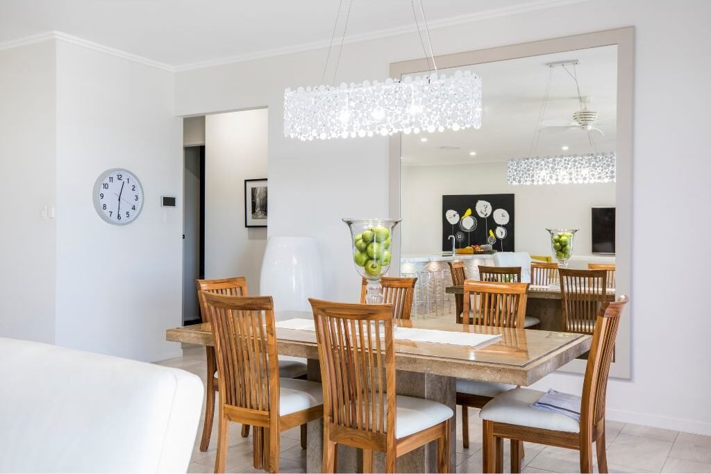 Wood dining table with fabric chairs in bright room