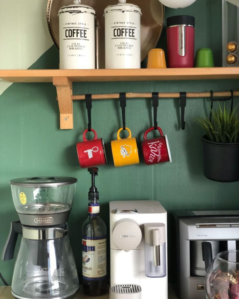 Wall-mounted mug hooks with coffee station accessories below