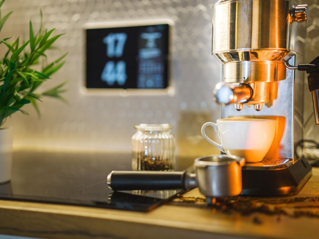 Espresso machine brewing into a ceramic cup with gold accents