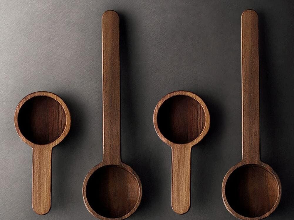Set of four wooden coffee spoons on a dark background