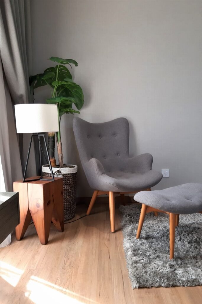 Gray armchair with side table and modern decor.