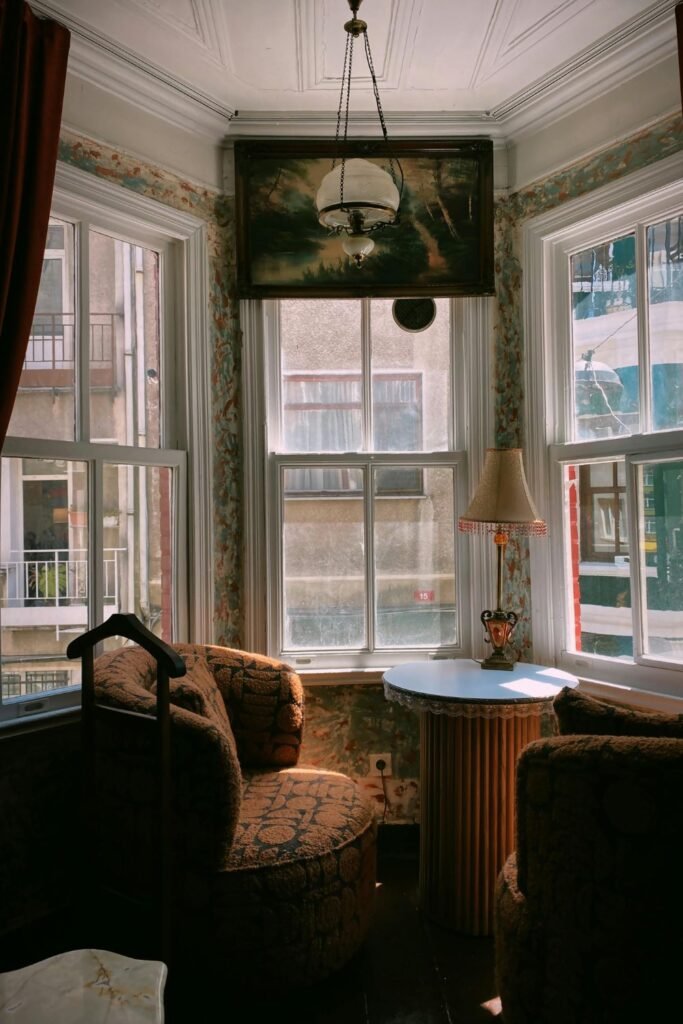 Armchair set beside bookshelf with warm ambiance.